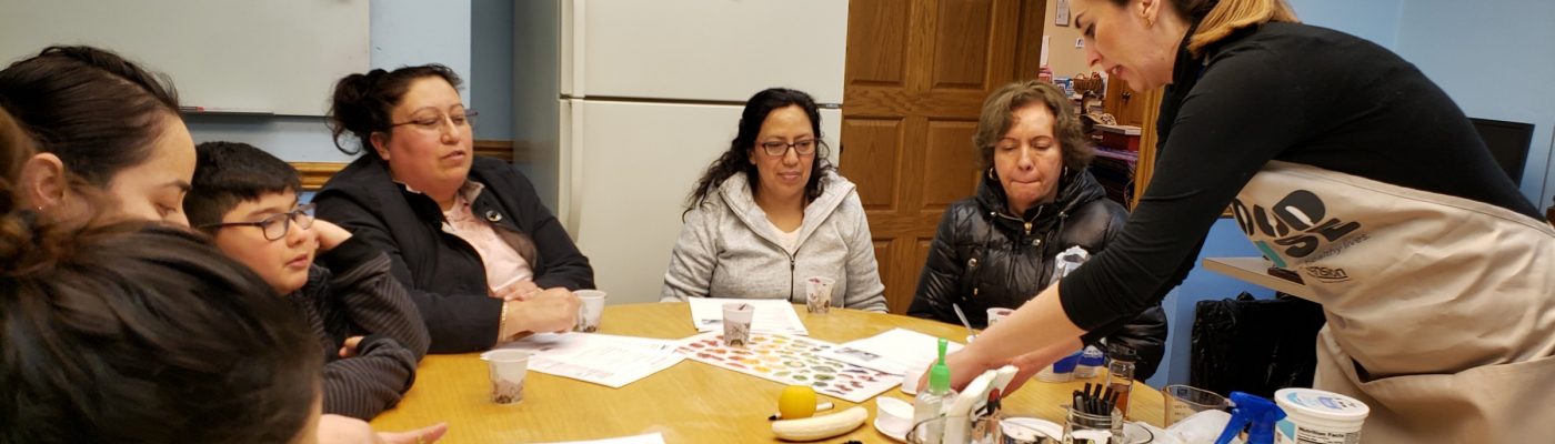 Food educator demonstrating best food practices to a group of women seated at a table